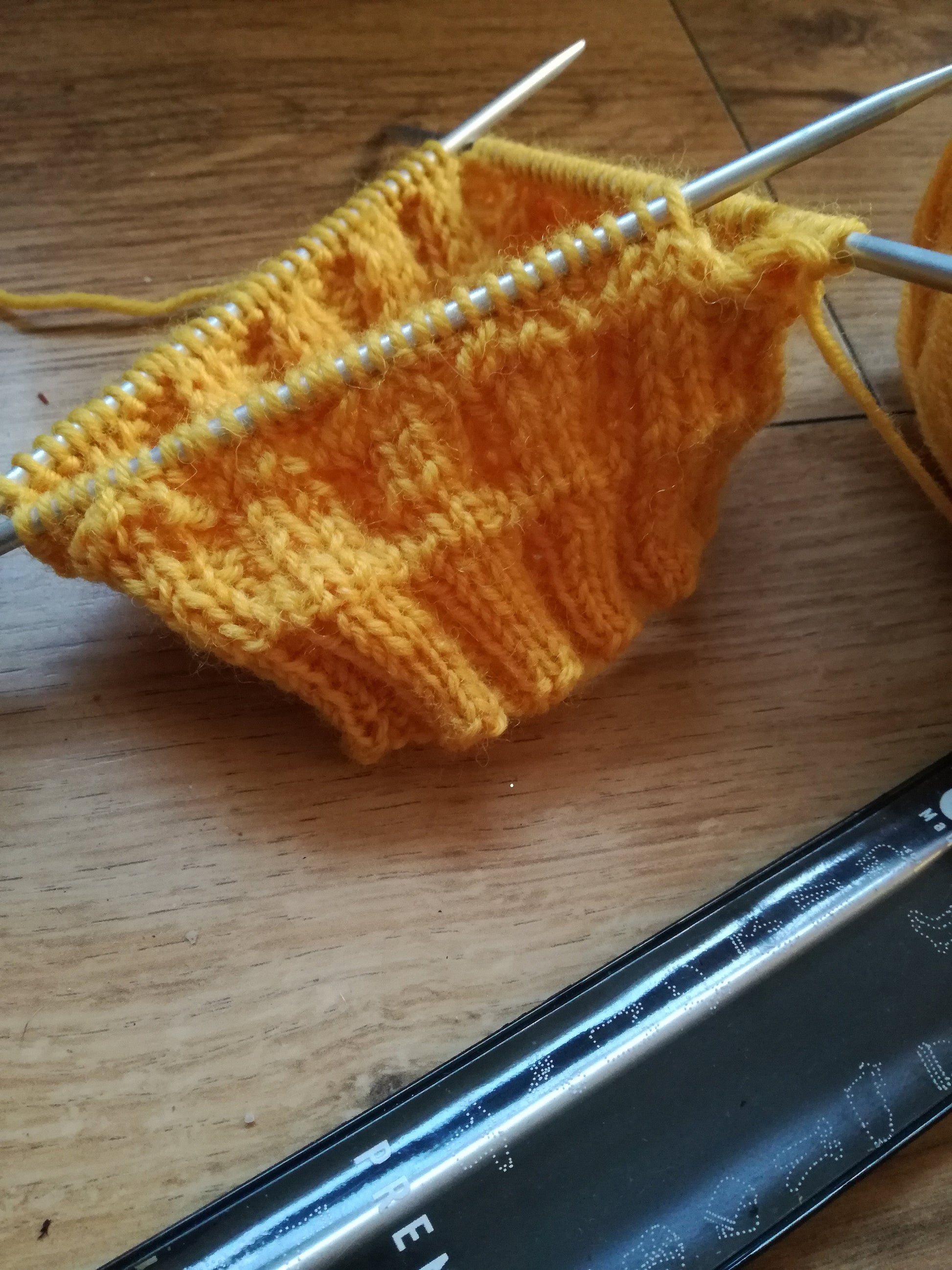 Addi knitting needles on a hat. 