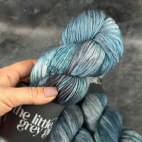 The disturbia yarn is a bio sock base with biodegradable nylon. This is a close up of the yarn. It has blue and grey flecks as well as creams and very light blue